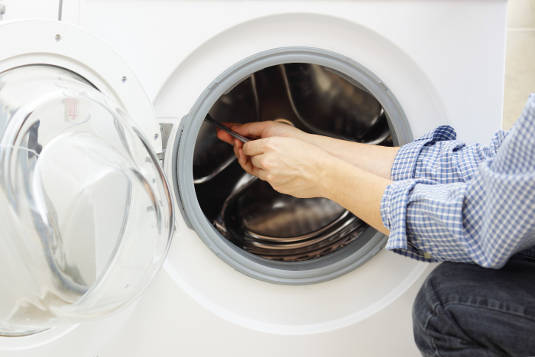 Repair Technician Repairing Washer